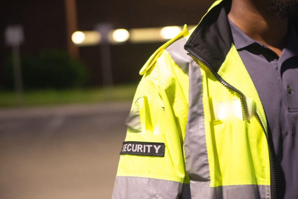 Close-up of a security guard's high-visibility jacket with the word 'SECURITY' on a patch, during night duty in Pretoria