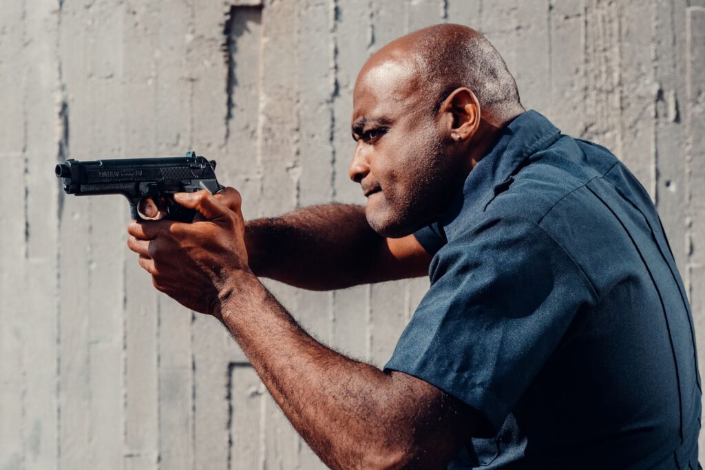 Focused armed security officer in Pretoria aiming a handgun during target practice, demonstrating professional training and readiness