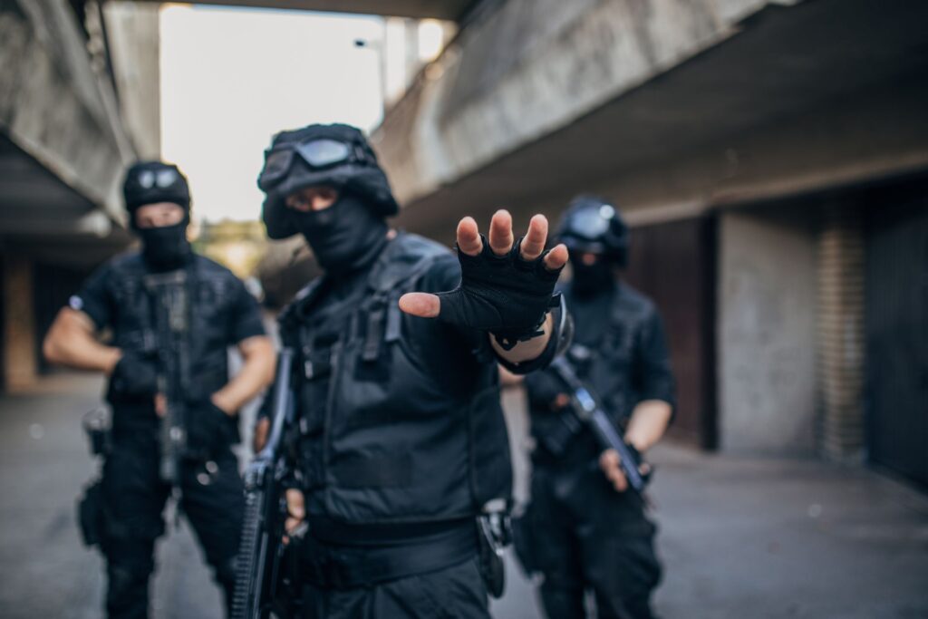 Specialized armed response unit in tactical gear gesturing to stop, prepared for an urban operation in Pretoria